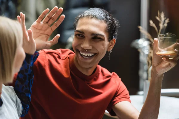 Cheerful interracial couple with coffee giving high five in cafe — Stock Photo