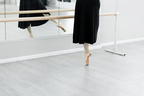 Partial view of ballet dancer practicing at barre near mirrors — Stock Photo