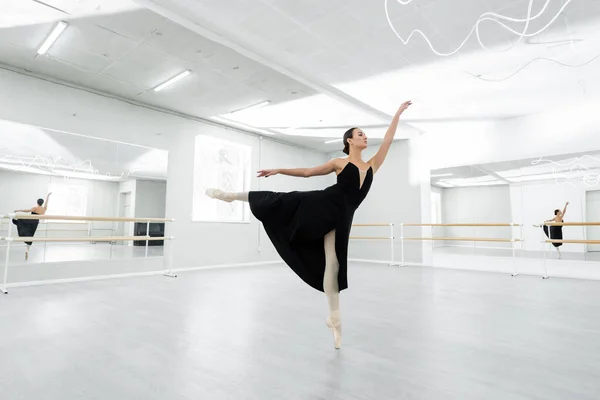 Full length view of ballerina dancing in studio during repetition — Stock Photo