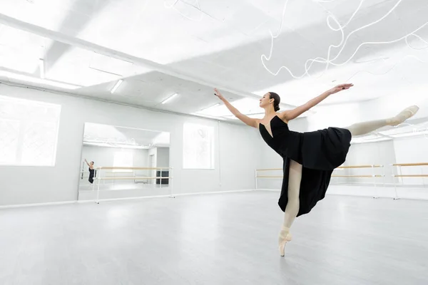Full length view of ballerina dancing in spacious studio during repetition — Stock Photo