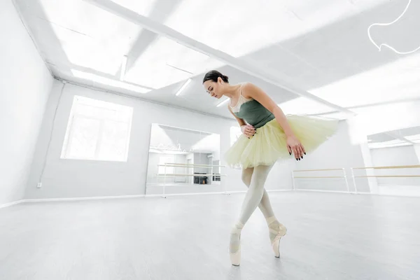 Visão completa da bailarina morena ensaiando em estúdio — Fotografia de Stock