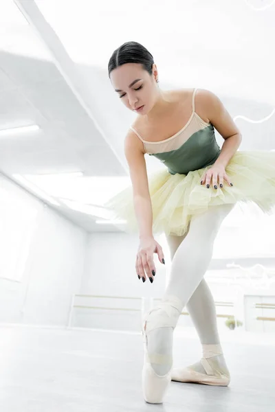 Low angle view of young ballerina training in dancing hall — Stock Photo