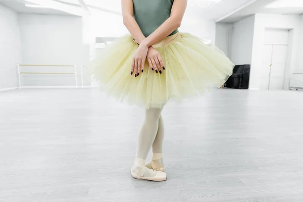 Vista recortada de bailarina en tutú y zapatos puntiagudos ensayando en salón de baile - foto de stock