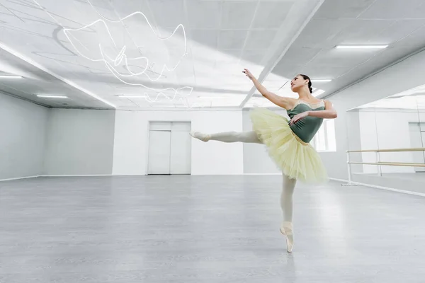 Bailarina jovem e magro ensaiando dança no estúdio de balé — Fotografia de Stock