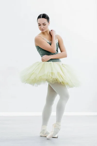 Full length view of slim ballerina in tutu dancing in studio — Stock Photo