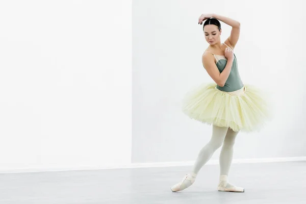 Vue complète de la gracieuse ballerine en tutu dansant en studio — Photo de stock