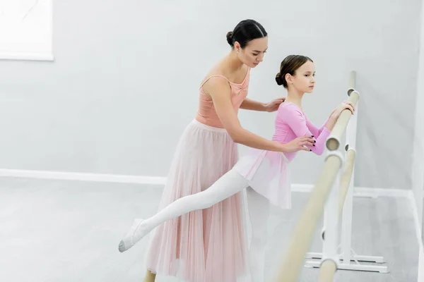 Тонка дівчина тренується в танцювальній студії біля молодого майстра балету — стокове фото