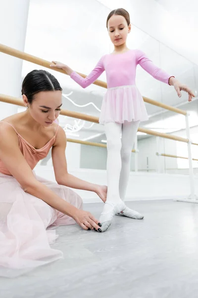 Jeune ballerine assister fille pendant la formation en studio de danse — Photo de stock