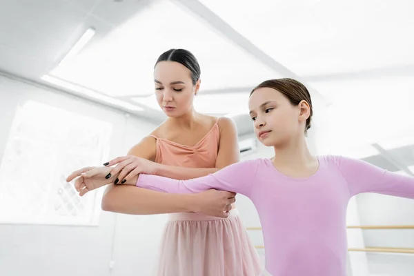 Professeur de danse aidant fille préadolescente à apprendre dans l'école de ballet — Photo de stock
