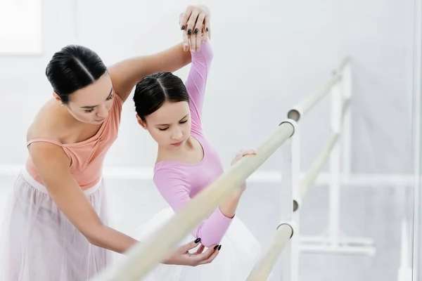 Balé mestre professor menina no barre em primeiro plano desfocado — Fotografia de Stock