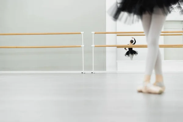 Menina borrada dançando no estúdio de balé perto de reflexão no espelho no fundo — Fotografia de Stock