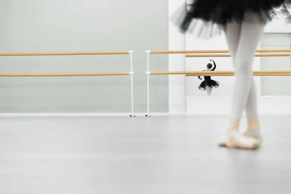 Blurred girl dancing in ballet studio near reflection in mirror on background — Stock Photo