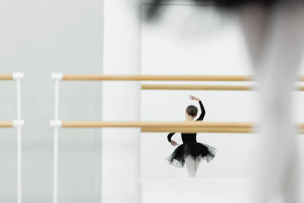 Mirror reflection of girl dancing in ballet studio, blurred foreground — Stock Photo