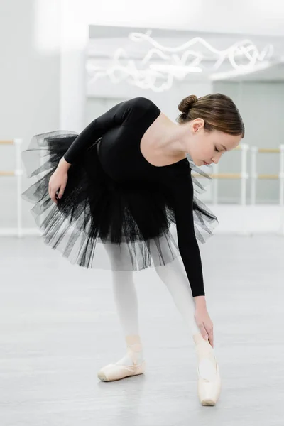 Preteen girl in black tutu training in ballet school — Stock Photo