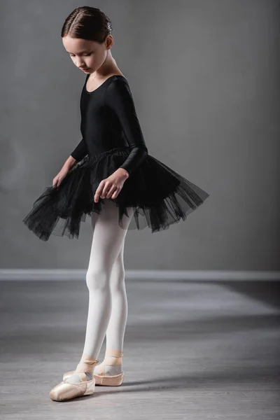 Vista completa de chica en tutú negro bailando en estudio de ballet - foto de stock