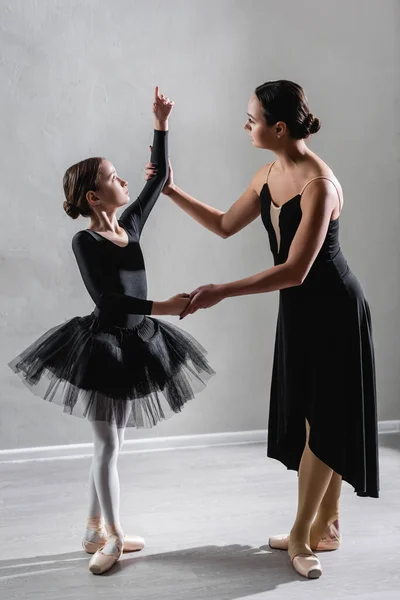 Piena vista di ballerina insegnare ragazza a ballare balletto in studio — Foto stock