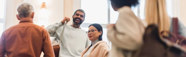 Positivo Africano americano estudante segurando mochila perto asiático amigo e professor na universidade, banner — Fotografia de Stock