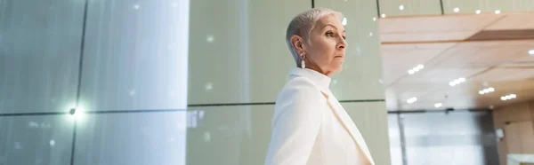Side view of fashionable senior business lady in hotel lobby, banner — Stock Photo