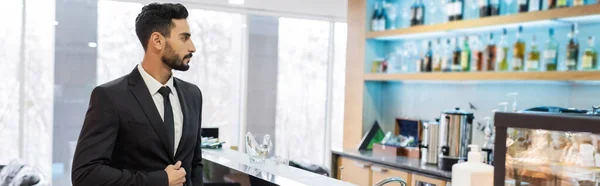 Bi-racial security man in suit standing at bar counter in hotel lobby, banner — Stock Photo