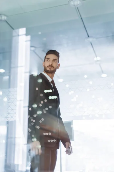 Low angle view of bi-racial guard in suit in hotel lobby on blurred foreground — Stock Photo