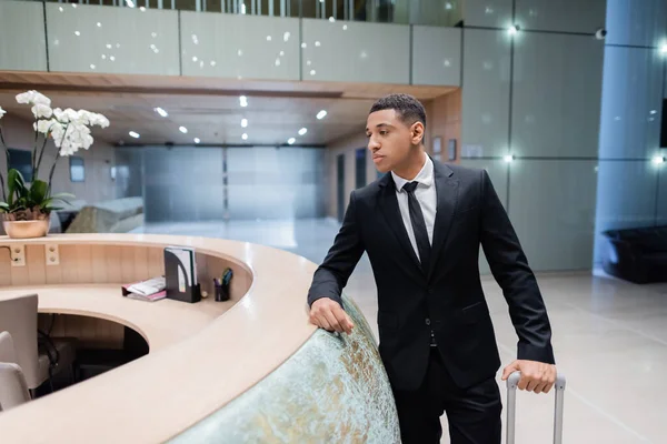 African american guard in black suit standing near hotel reception, banner — Stock Photo