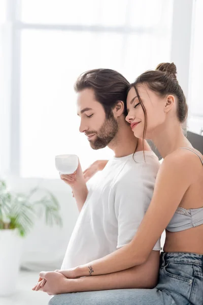 Tattooed woman in bra holding hands with young boyfriend — Stock Photo