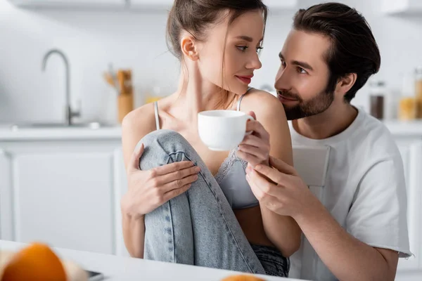 Heureux barbu homme toucher la main de petite amie avec tasse — Photo de stock