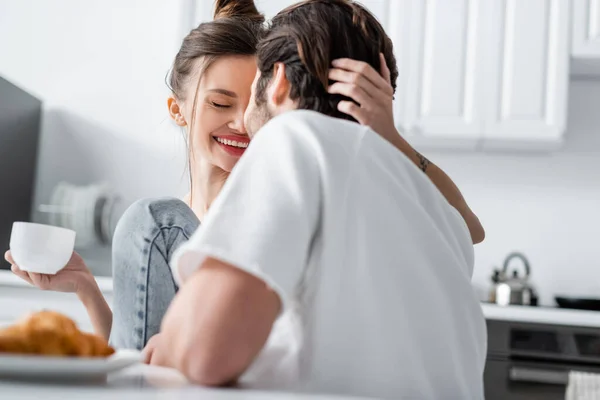 Positiva giovane donna in possesso di tazza e abbracciare il fidanzato — Foto stock