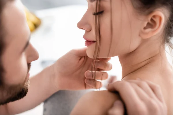 Nahaufnahme eines bärtigen Mannes, der das Gesicht seiner Freundin berührt — Stockfoto