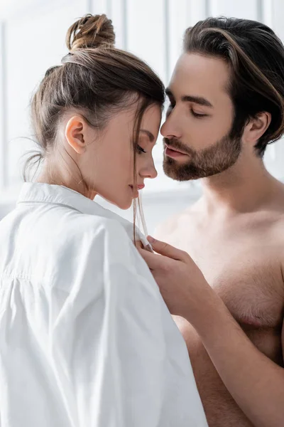 Hemdloser Mann verführt junge Freundin im weißen Hemd — Stockfoto