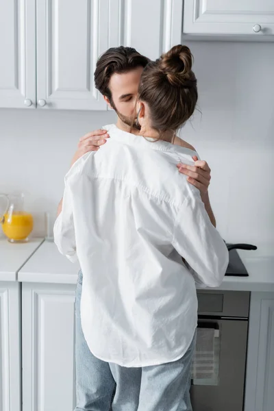 Bearded man taking off white shirt on girlfriend — Stock Photo