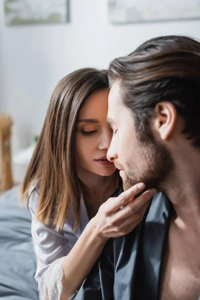 Giovane donna volto toccante di uomo barbuto — Foto stock