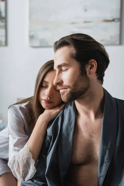 Young woman in silk robe leaning on shoulder of bearded man — Stock Photo