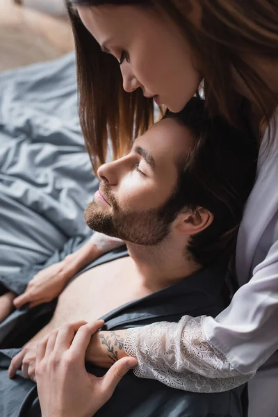 Young woman hugging bearded boyfriend in robe — Stock Photo