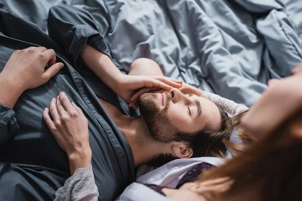 Vue du dessus de la jeune femme étreignant petit ami barbu en robe — Photo de stock