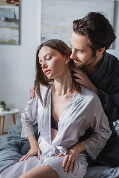 Barbudo homem seduzindo sensual mulher em seda robe — Fotografia de Stock