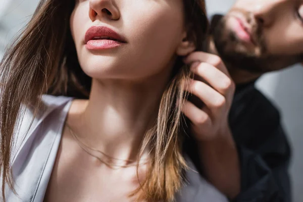 Abgeschnittene Ansicht eines bärtigen Mannes, der eine sinnliche Frau in Seidenrobe verführt — Stockfoto