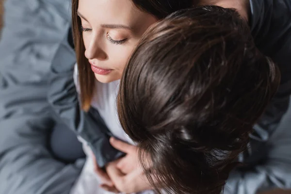 Top view of man hugging young woman woman in bedroom — Stock Photo