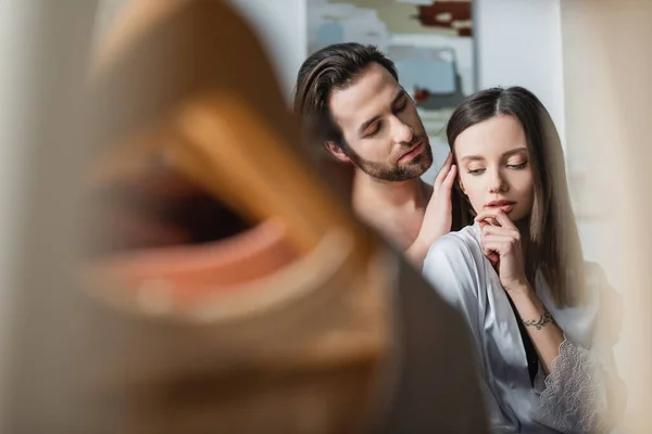 Junger Mann streichelt Haare tätowierter Freundin im Seidengewand — Stockfoto