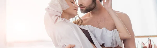 Bearded man hugging young woman in silk robe, banner — Stock Photo