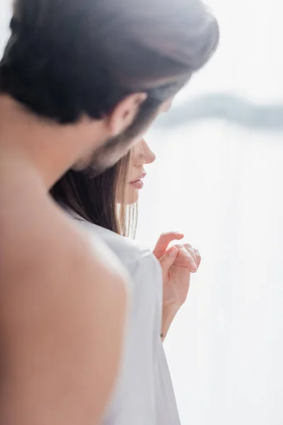 Homme flou et barbu près de jeune femme en robe de soie — Photo de stock