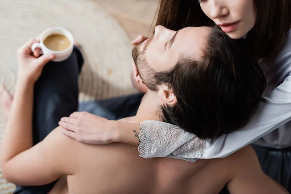 Vue grand angle de jeune femme tatouée séduisant homme barbu avec tasse de café — Photo de stock