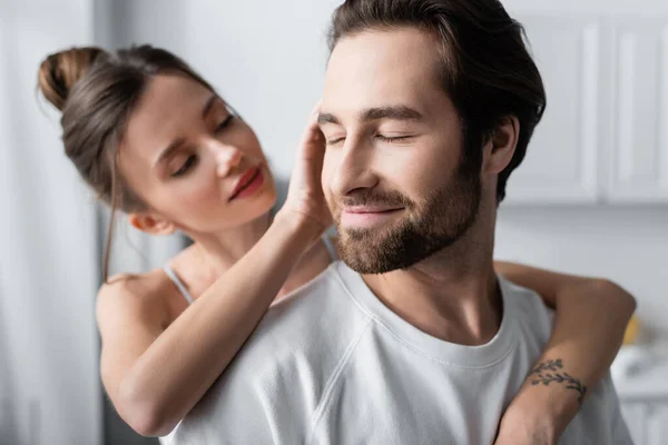 Jeune femme floue avec tatouage câlin heureux homme en t-shirt blanc — Photo de stock