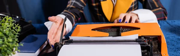 Vista parziale del giornalista che lavora alla macchina da scrivere vintage su tovaglia blu, banner — Foto stock