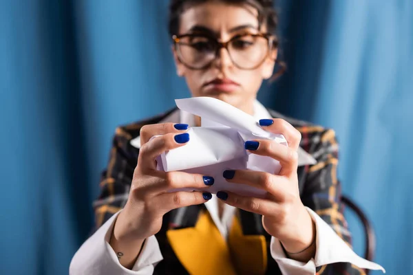 Mulher estilo vintage com unhas azuis crumpling papel no fundo borrado — Fotografia de Stock