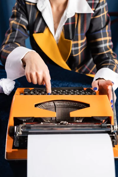 Cropped view of newswoman in stylish blazer typing on vintage typewriter — Stock Photo