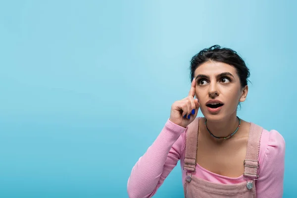 Femme étonnée avec la bouche ouverte ayant idée et toucher la tête isolé sur bleu — Photo de stock