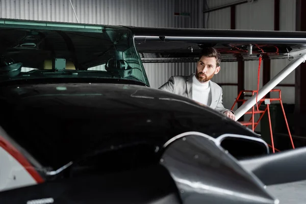 Bärtiger Mann schaut modernen Hubschrauber auf Parkplatz an — Stockfoto