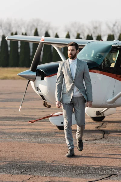 Full length of confident businessman walking near helicopter outdoors — Stock Photo