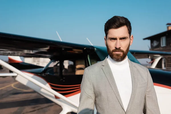 Businessman in suit standing near blurred helicopter outdoors — Stock Photo